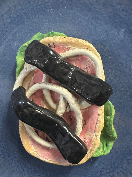 Rullepølsemad i keramik. skulptur til ophæng